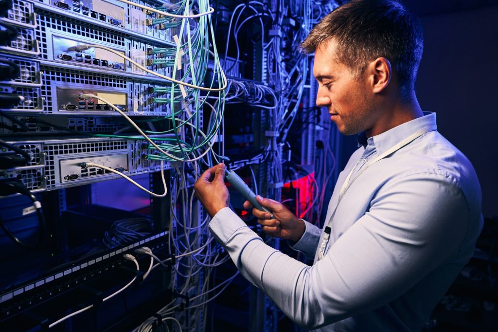 Focused data center employee checking cabling infrastructure